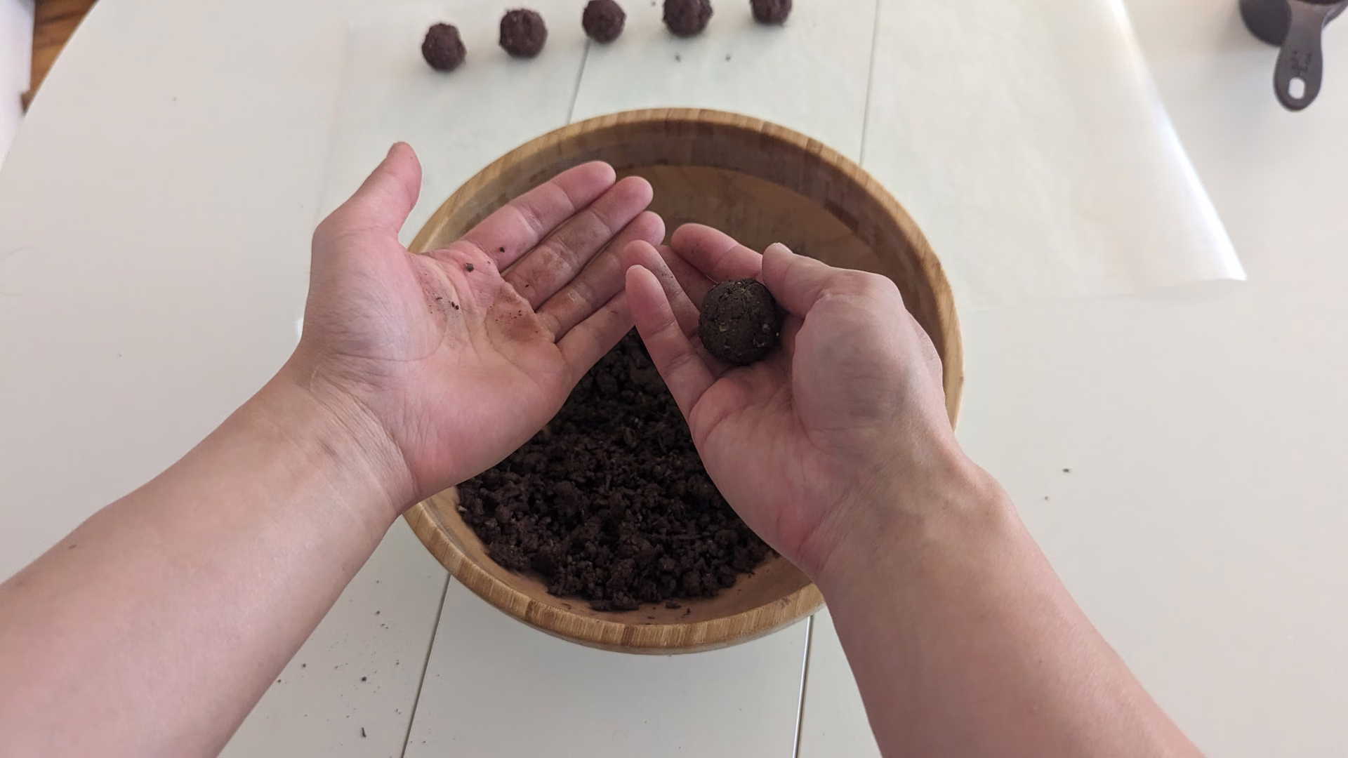 Rolling a seed bomb by hand over the mixing bowl